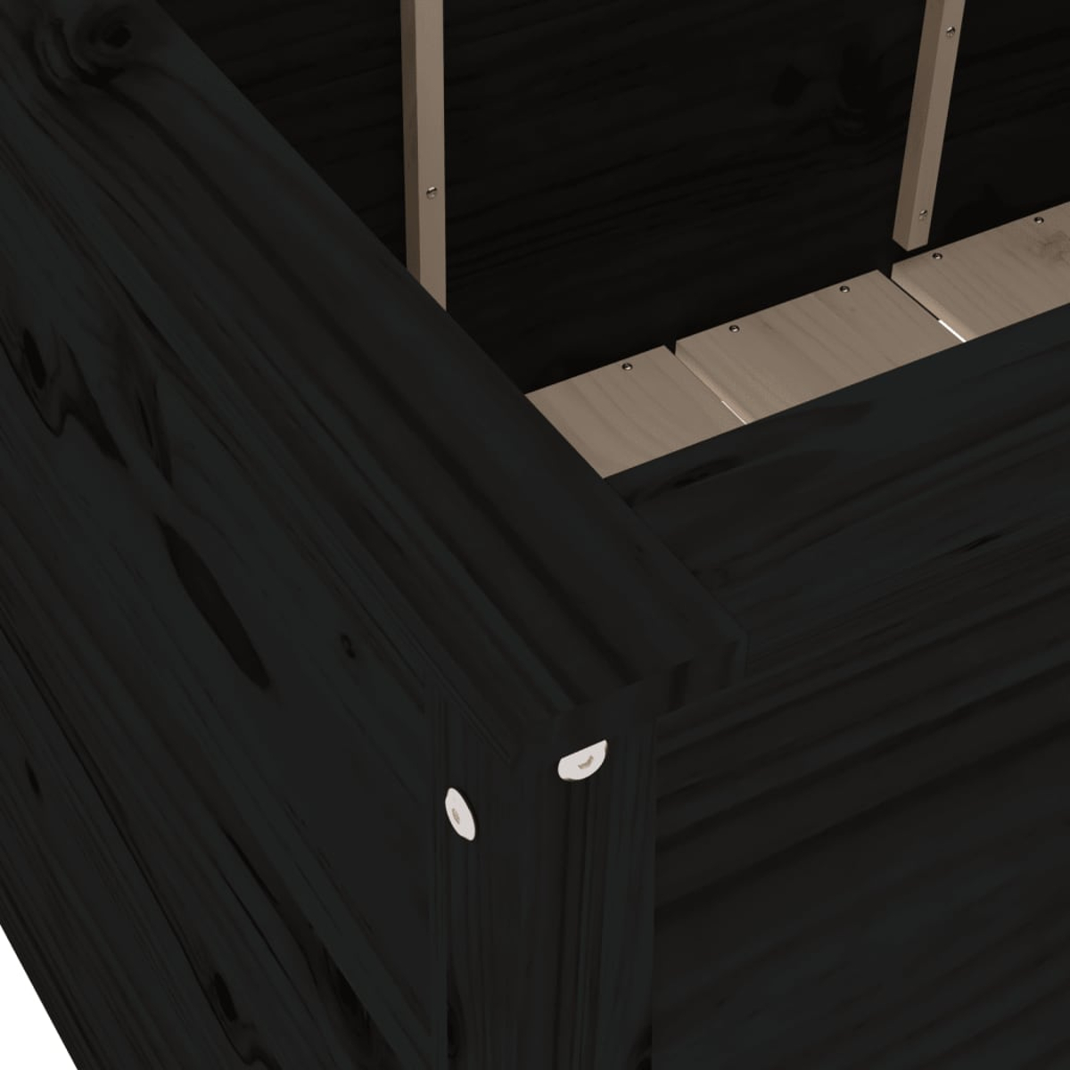 Nahaufnahme einer dunklen Holzecke. Zwei weiße Befestigungselemente sind sichtbar. Der Innenraum ist helleres Holz.