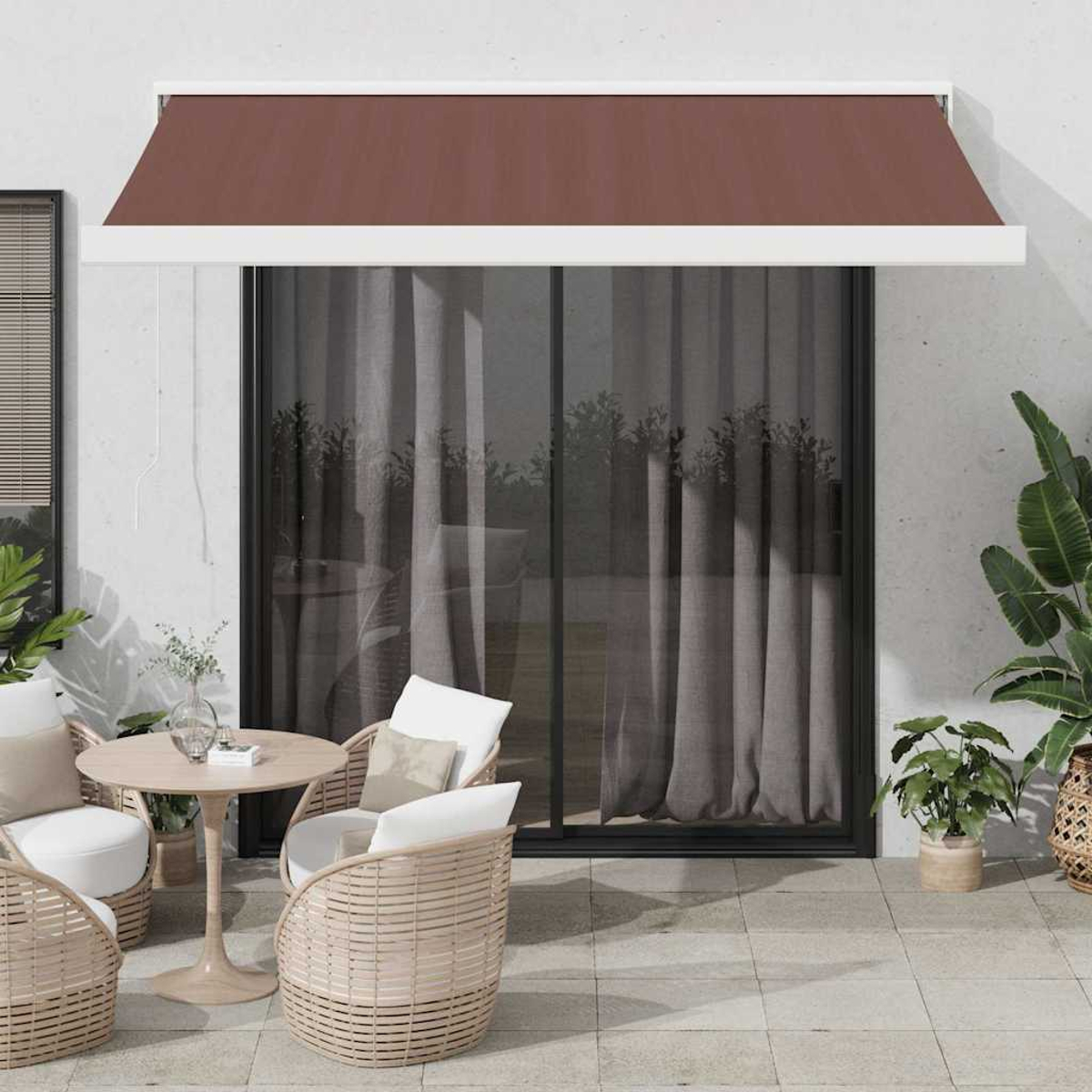 Patio con tenda da sole marrone estesa. Sedie e un tavolo di fronte a una porta scorrevole in vetro.