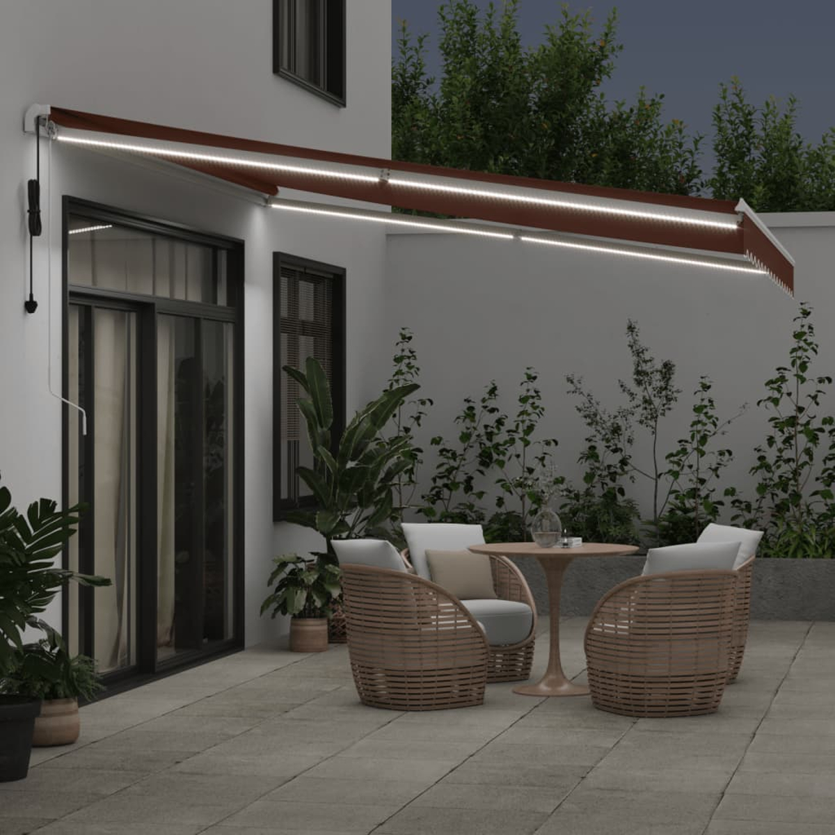 Terrasse im Freien mit Markise, Tisch, Stühlen und Pflanzen. Nachts beleuchtet.