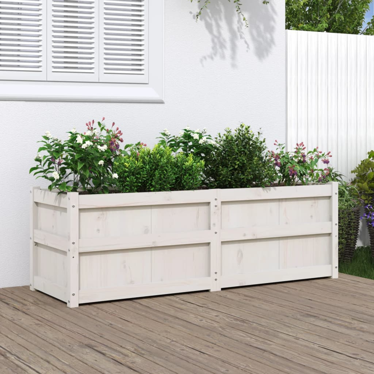 Ein weißes, erhöhtes Gartenbeet aus Holz mit Pflanzen wird auf einem Holzdeck gezeigt.