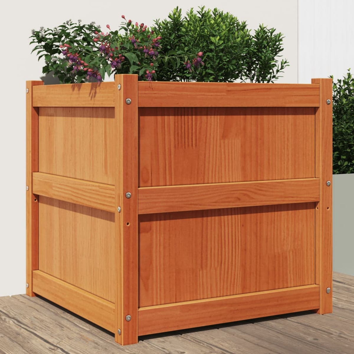 Ein hölzerner Pflanzkübel mit Pflanzen. Es steht auf einem Holzdeck. Der Pflanzkübel hat eine helle Holzfarbe.