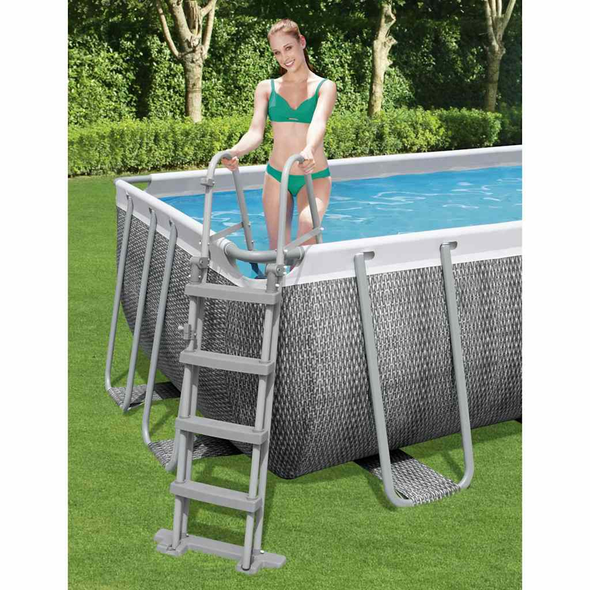 Eine Frau in einem grünen Bikini steigt über eine Leiter in einen Pool. Der Pool hat eine Flechttextur.