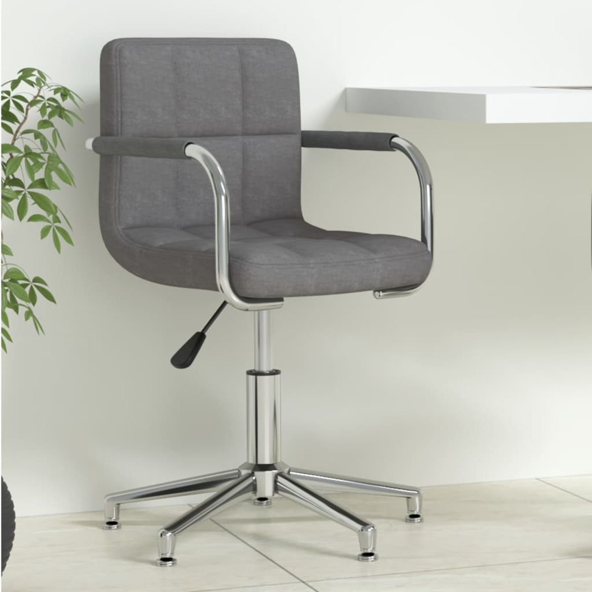Silla de oficina gris, base cromada, cerca de un escritorio blanco y planta verde.
