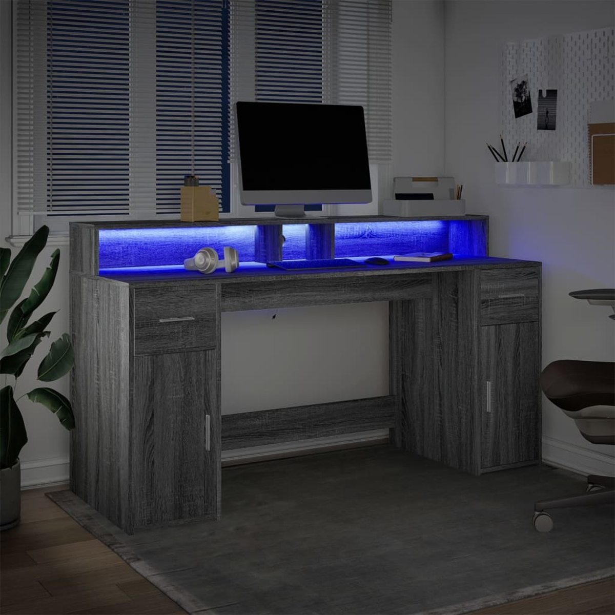 Grauer Computertisch mit Monitor, Tastatur und blauen LED-Leuchten.