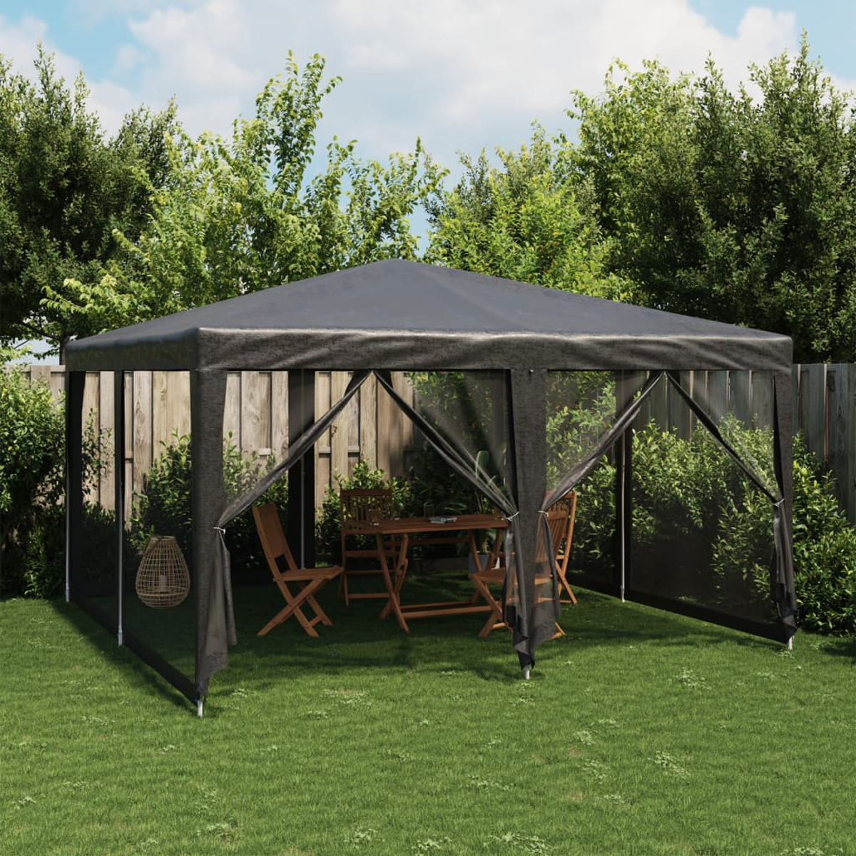 Gazebo nero sull'erba con tavolo e sedie all'interno.
