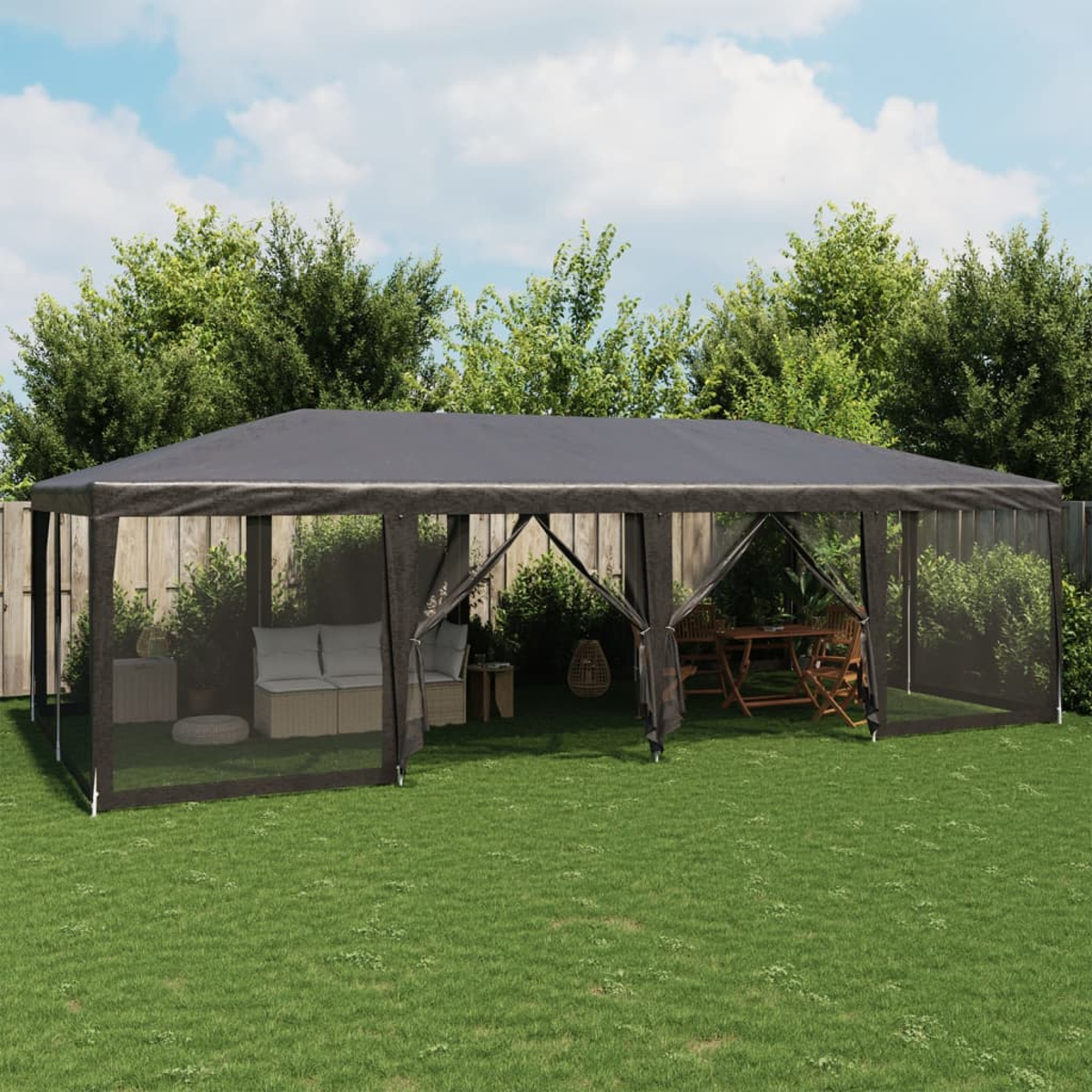 Gazebo esterno con lati in rete, un tavolo, sedie e un divano all'interno, su un prato verde.