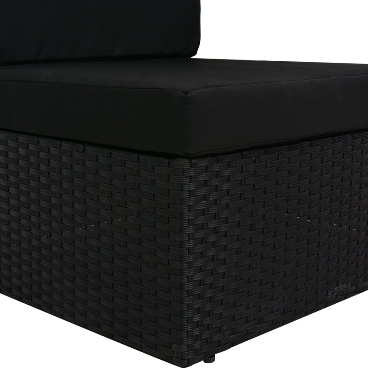Nahaufnahme eines schwarzen Ecksofas aus Korbgeflecht mit schwarzen Kissen, zeigt gewebte Texturdetails.