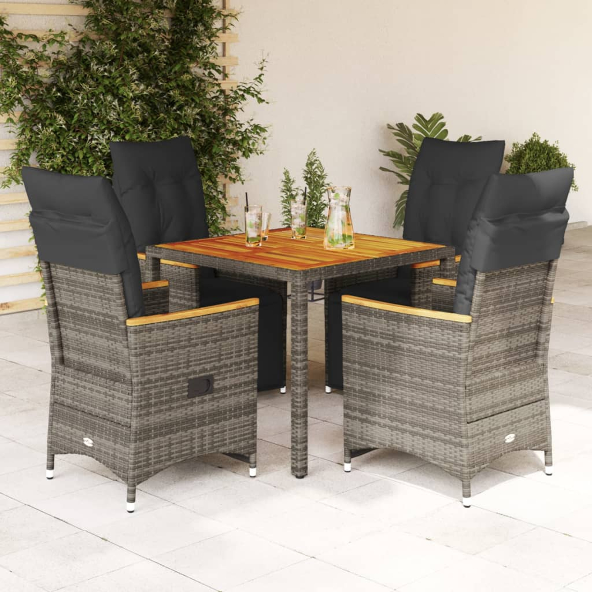Tisch mit vier Stühlen, graues Korbgeflecht mit Holz, schwarze Kissen, Getränke.