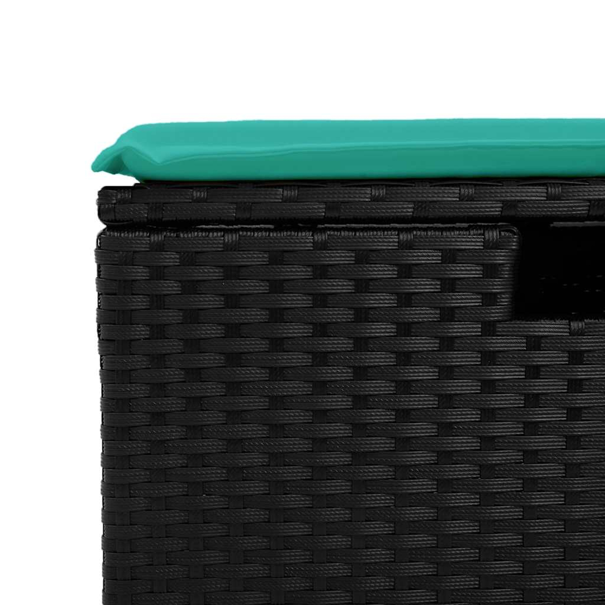 Primo piano di un contenitore nero in vimini con cuscino verde acqua sopra.