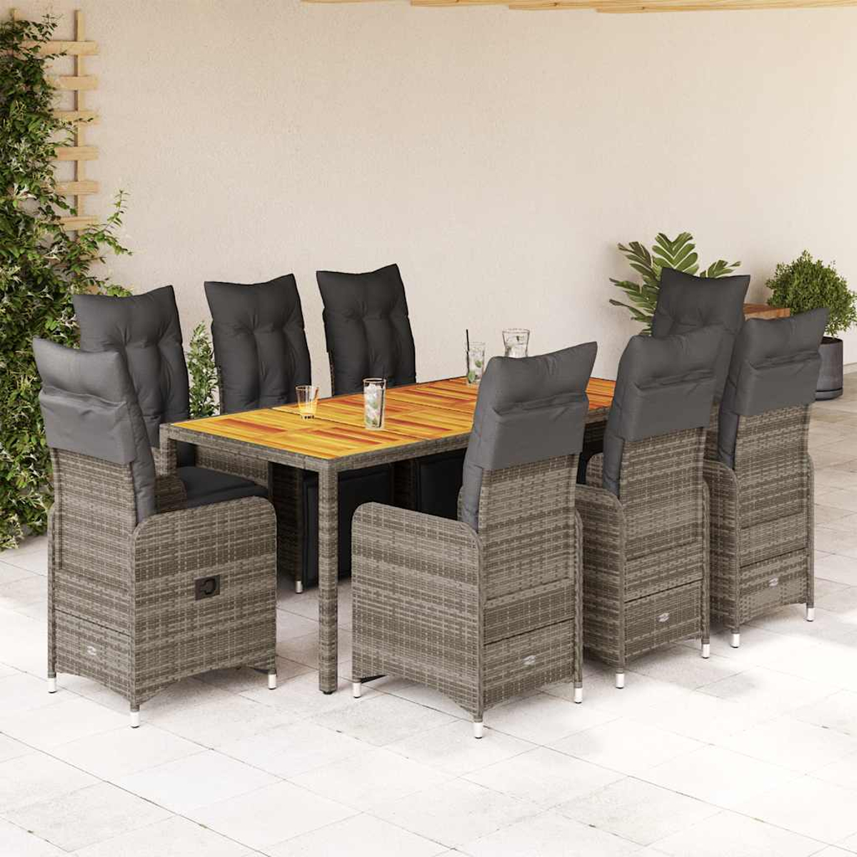 Set da pranzo per esterni con tavolo, sedie e cuscini. Su un patio con parete dai colori neutri.