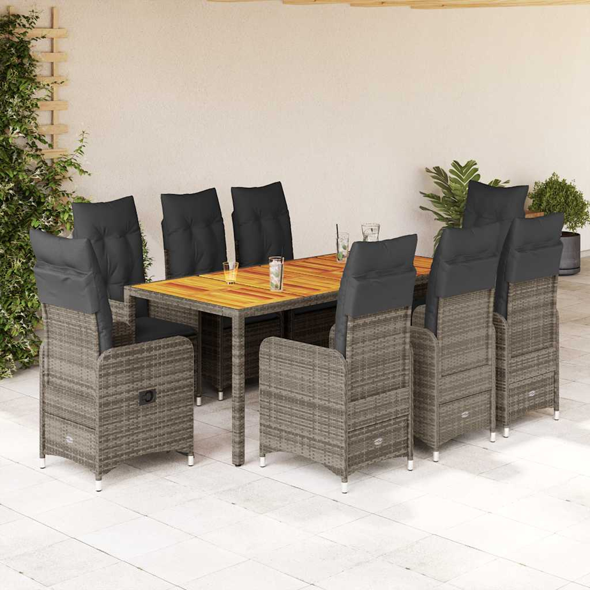 Rattanesstisch mit 8 Stühlen, Kissen, Holztisch und Pflanzen. Schwarze Kissen.