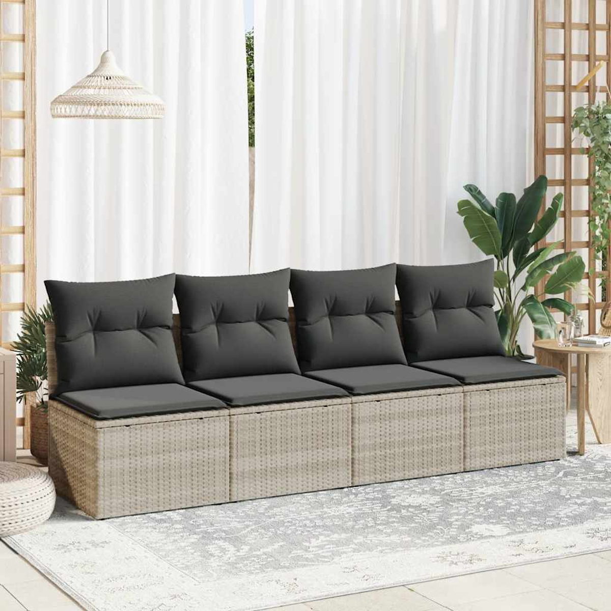 Beiges Rattansofa mit 4 grauen Kissen in einem sonnigen Außenbereich.