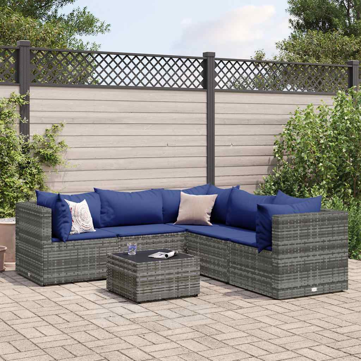 Un divano angolare in rattan grigio con cuscini blu e un tavolino.