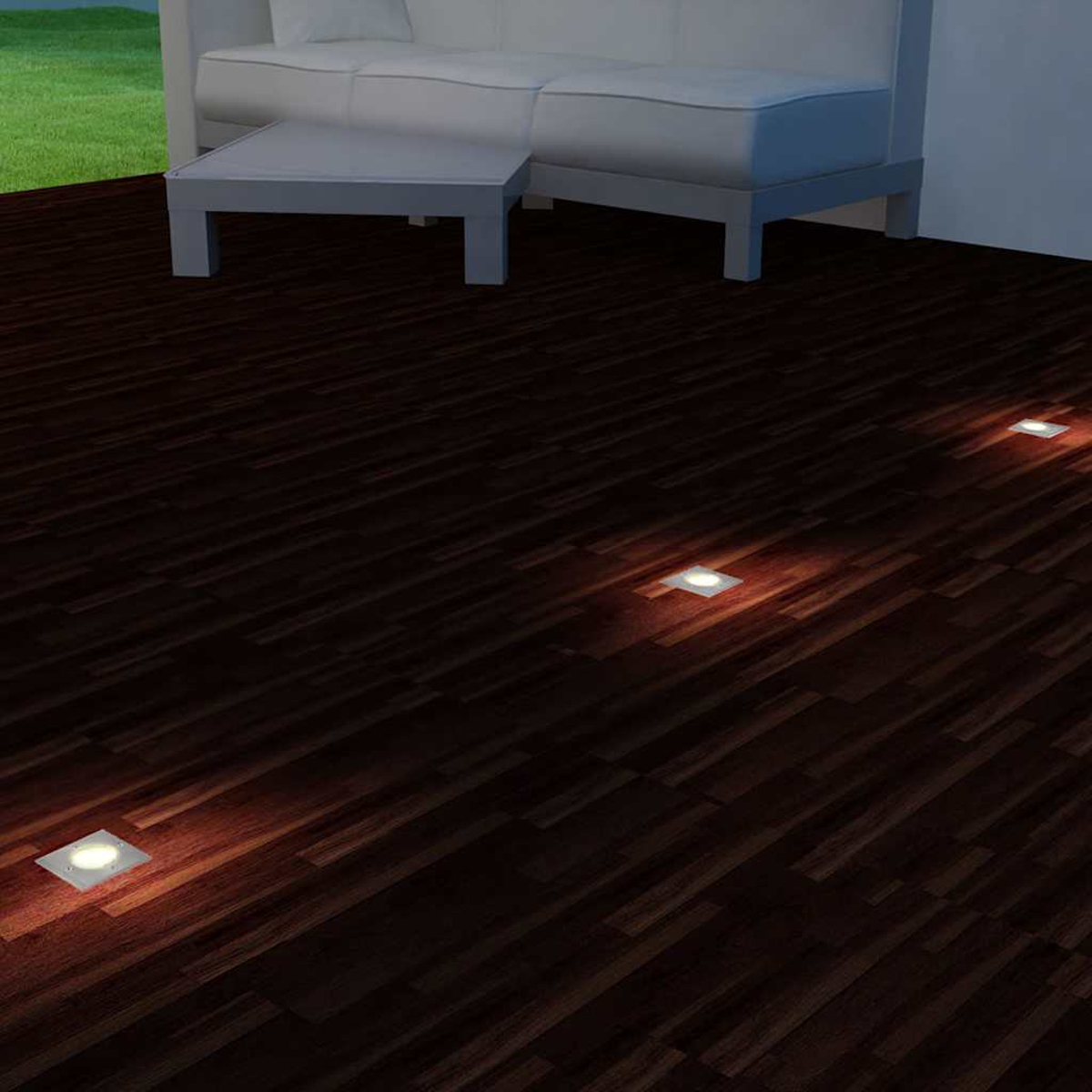 Pavimento in legno scuro con luci quadrate incassate, un divano bianco e un tavolino.