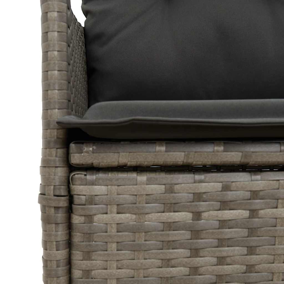 Primo piano di una sedia in rattan con cuscino nero. Il dettaglio della trama è visibile. Tonalità di grigio.