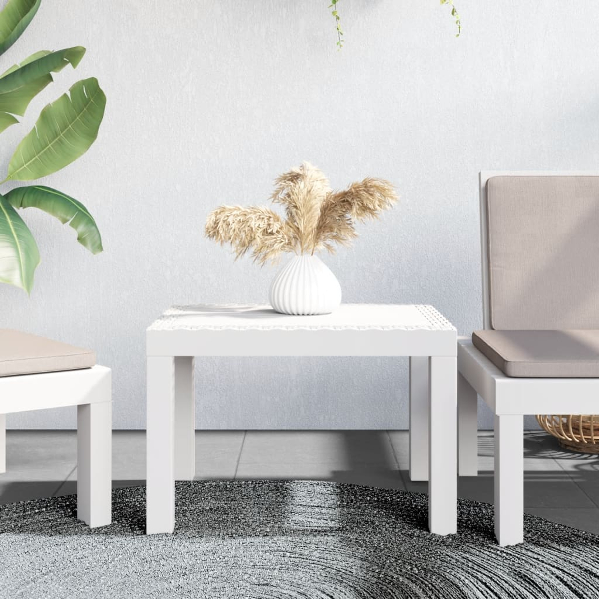 Ein weißer Tisch mit Vase und Teppich, mit Stühlen. Die Szene ist im Freien.
