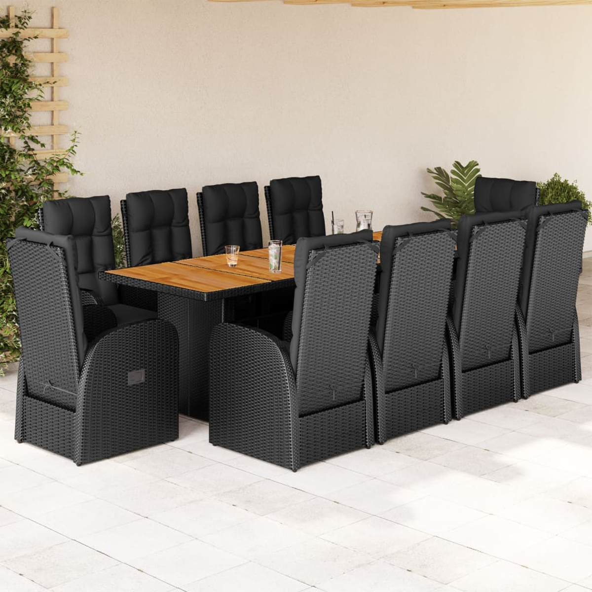 Set da pranzo all'aperto con sedie nere intrecciate e tavolo in legno.