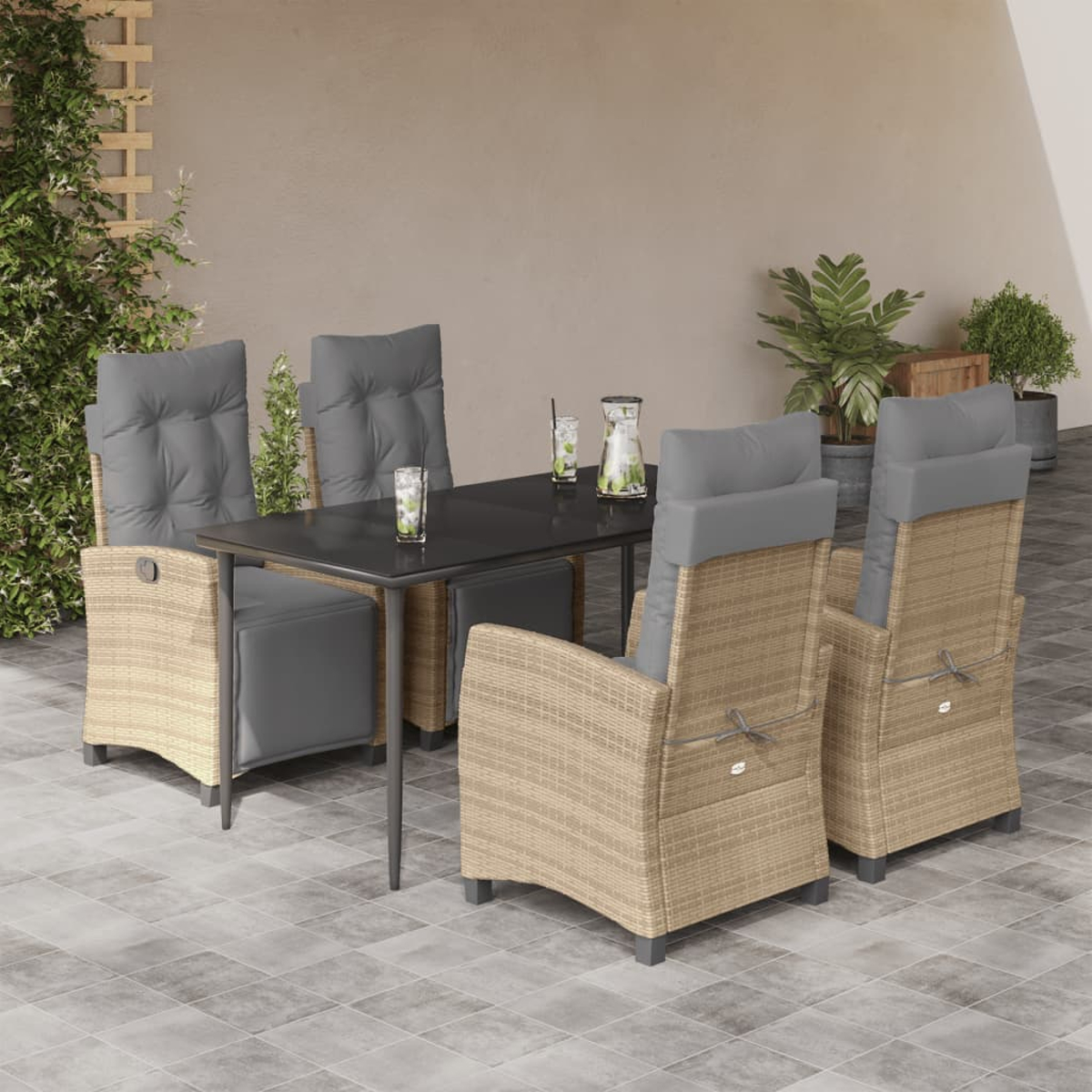 Set da pranzo per esterni con cuscini grigi e tavolo nero. Sedie in rattan beige. Sfondo: muro.