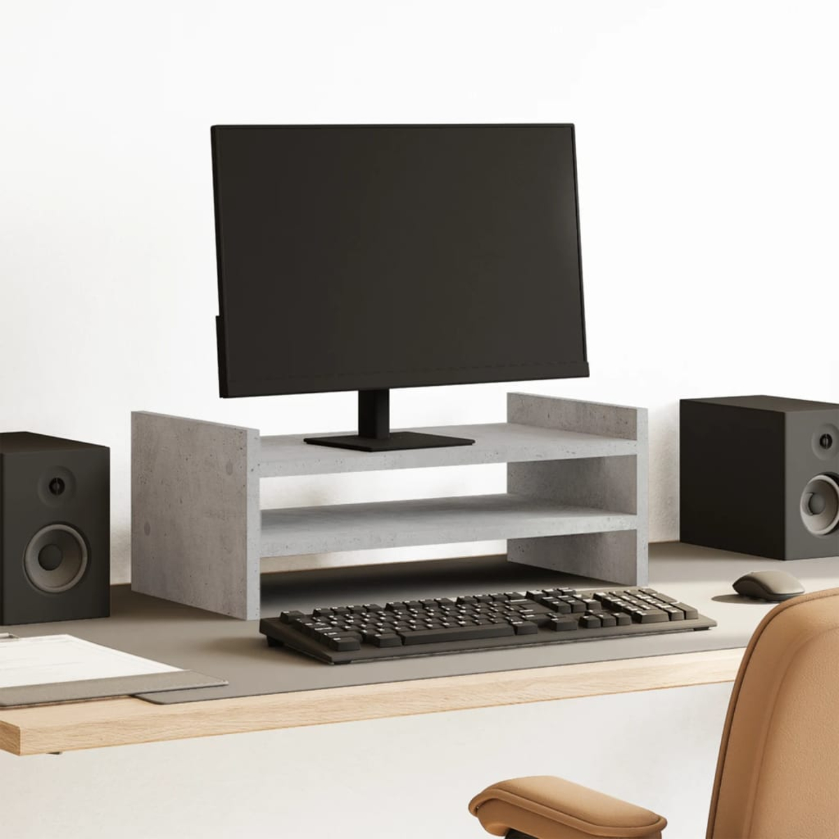 Schreibtisch mit Monitor, Lautsprechern und Tastatur.