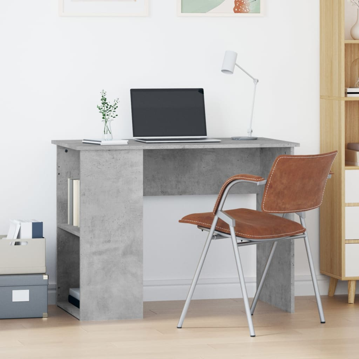 Schreibtisch mit Laptop, Büchern und Stuhl vor weißer Wand.