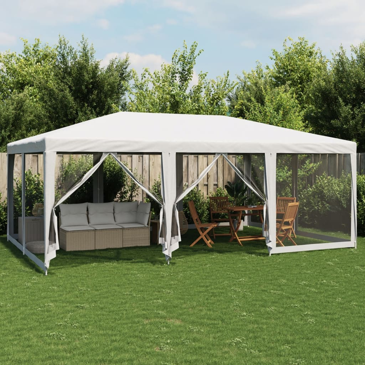 Una tenda a baldacchino da esterno allestita sull'erba, con mobili all'interno e un giardino sullo sfondo.