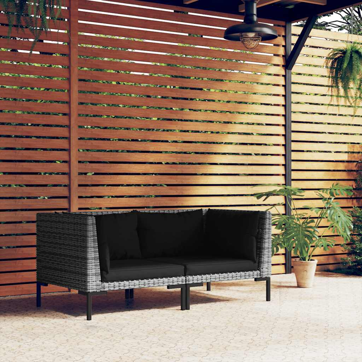 Outdoor-Sofa mit schwarzen Kissen, in einer Outdoor-Umgebung mit Holz-Hintergrund gezeigt.