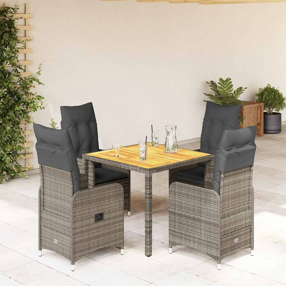 Rattantisch und Stühle Set. Die Stühle haben graue Kissen. Gläser und eine Kanne stehen auf dem Tisch.