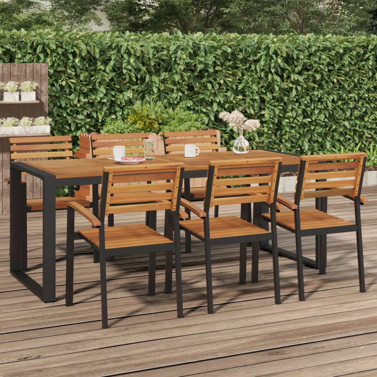 Essgruppe im Freien mit Holztisch und Stühlen. Grüner Hintergrund und Holzterrasse.