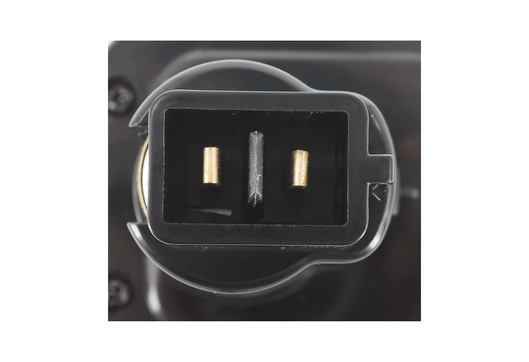 Nahaufnahme eines schwarzen Batterieanschlusses mit zwei goldfarbenen Stiften.