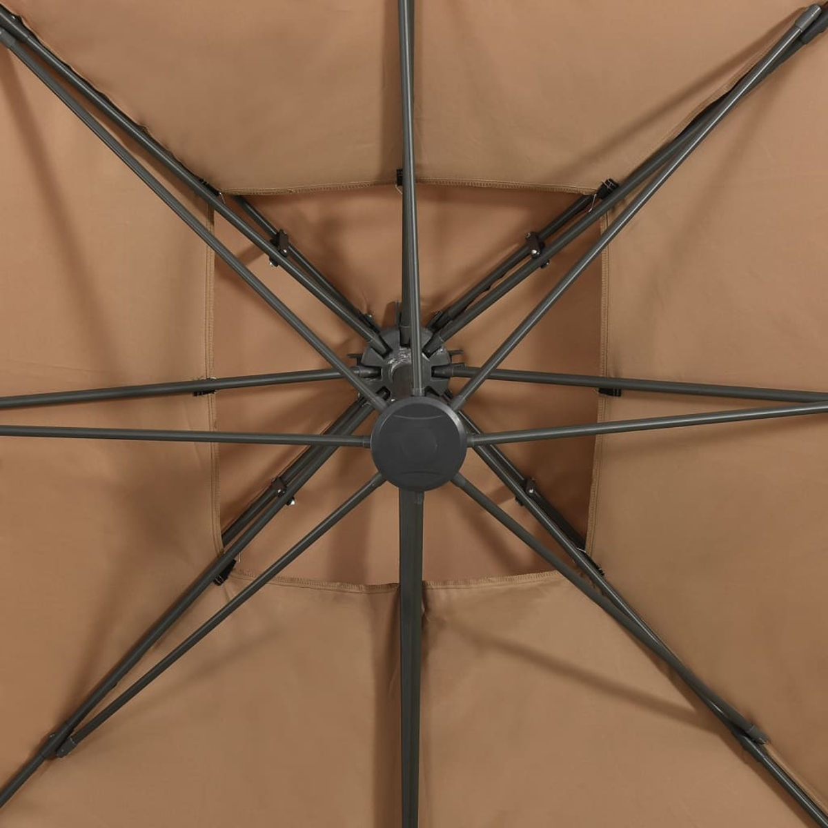 Nahaufnahme des Schirminneren. Beiges Gewebe, schwarze Stützbalken und zentrale Nabe.