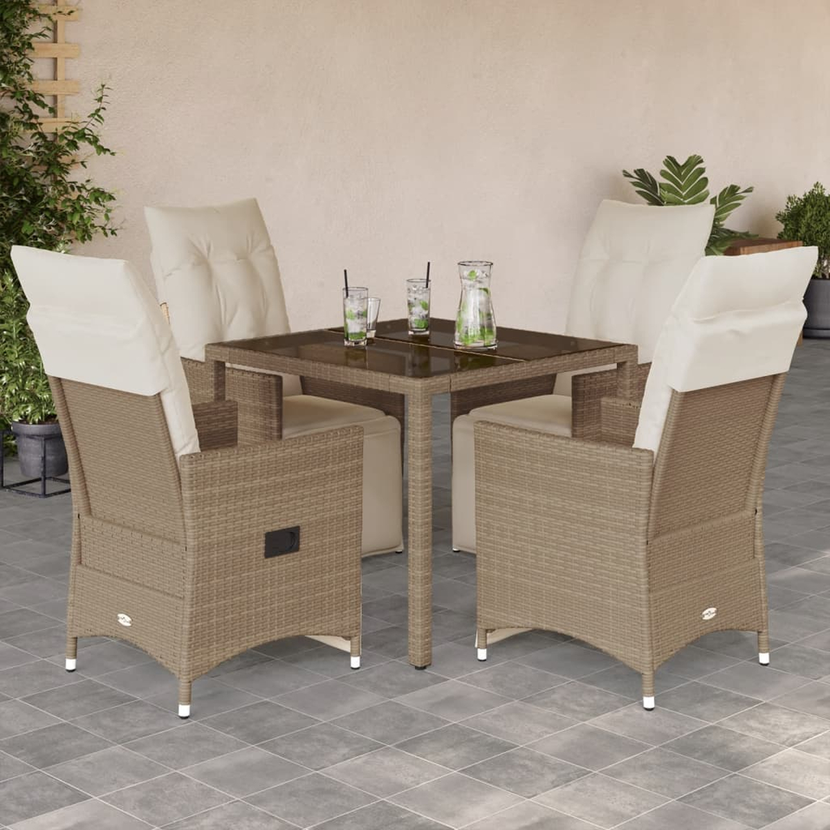Geflochtenes Möbelset auf einer Terrasse. Enthält Tisch, Stühle, Getränke und Pflanzen im Hintergrund.