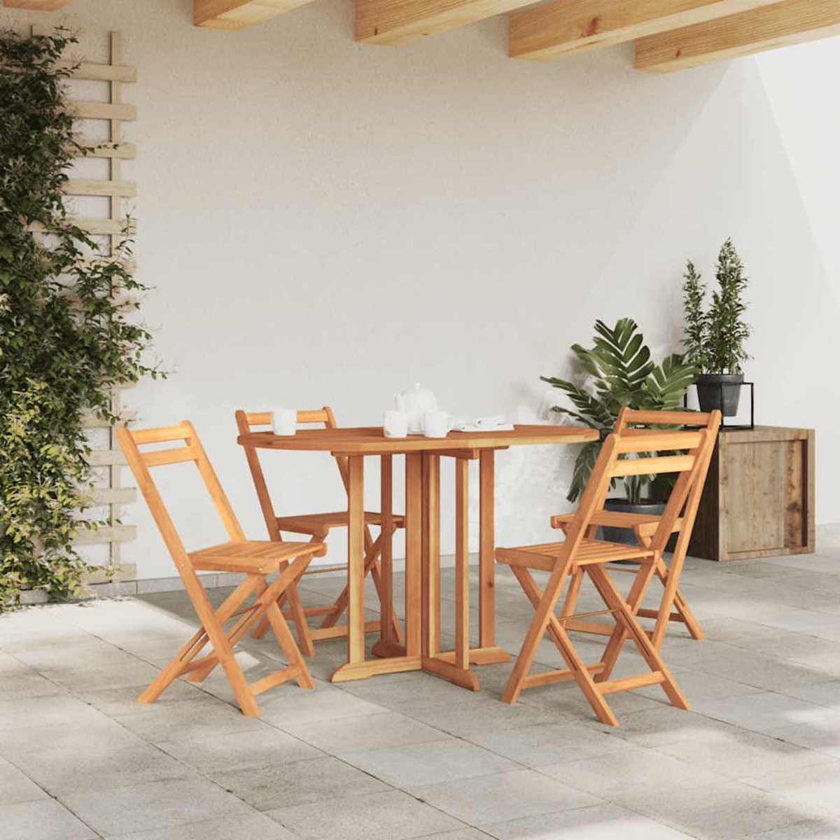 Garnitur aus Holztisch und Stühlen im Freien auf einer Terrasse, mit Pflanzen.