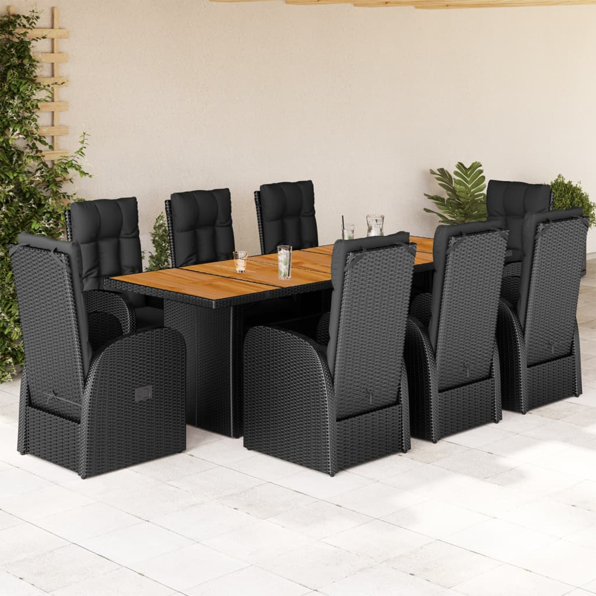 Set da pranzo in vimini nero con tavolo e sedie. Tavolo con piano in legno. Cuscini neri.