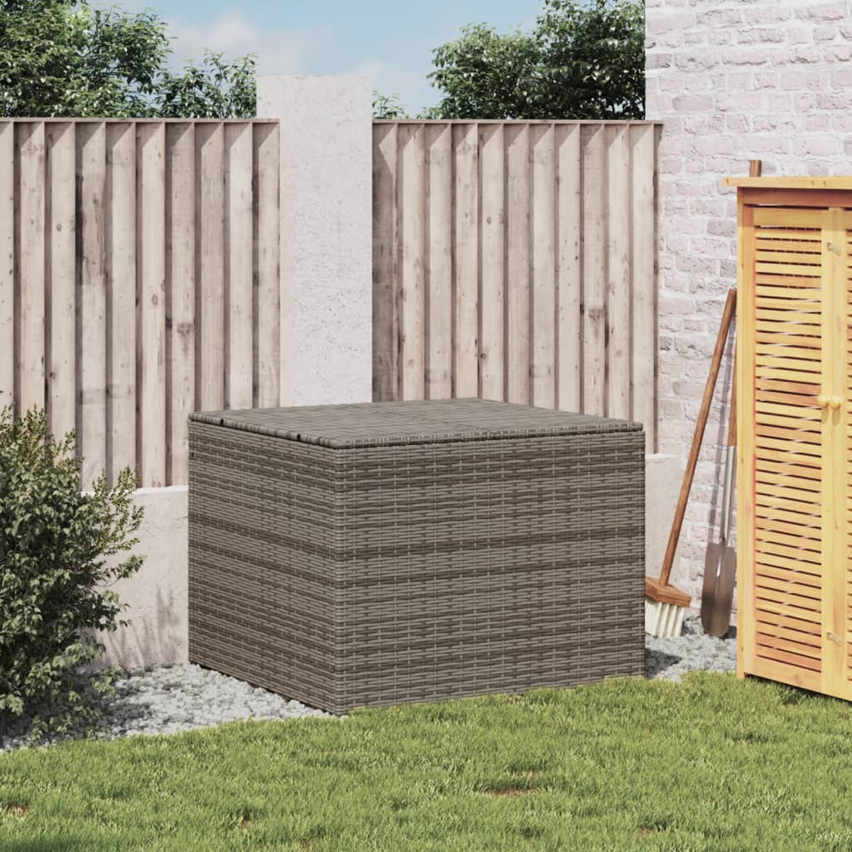 Aufbewahrungsbox aus Korbgeflecht draußen auf Gras, nahe einem Zaun. Hintergrund mit Schuppen.