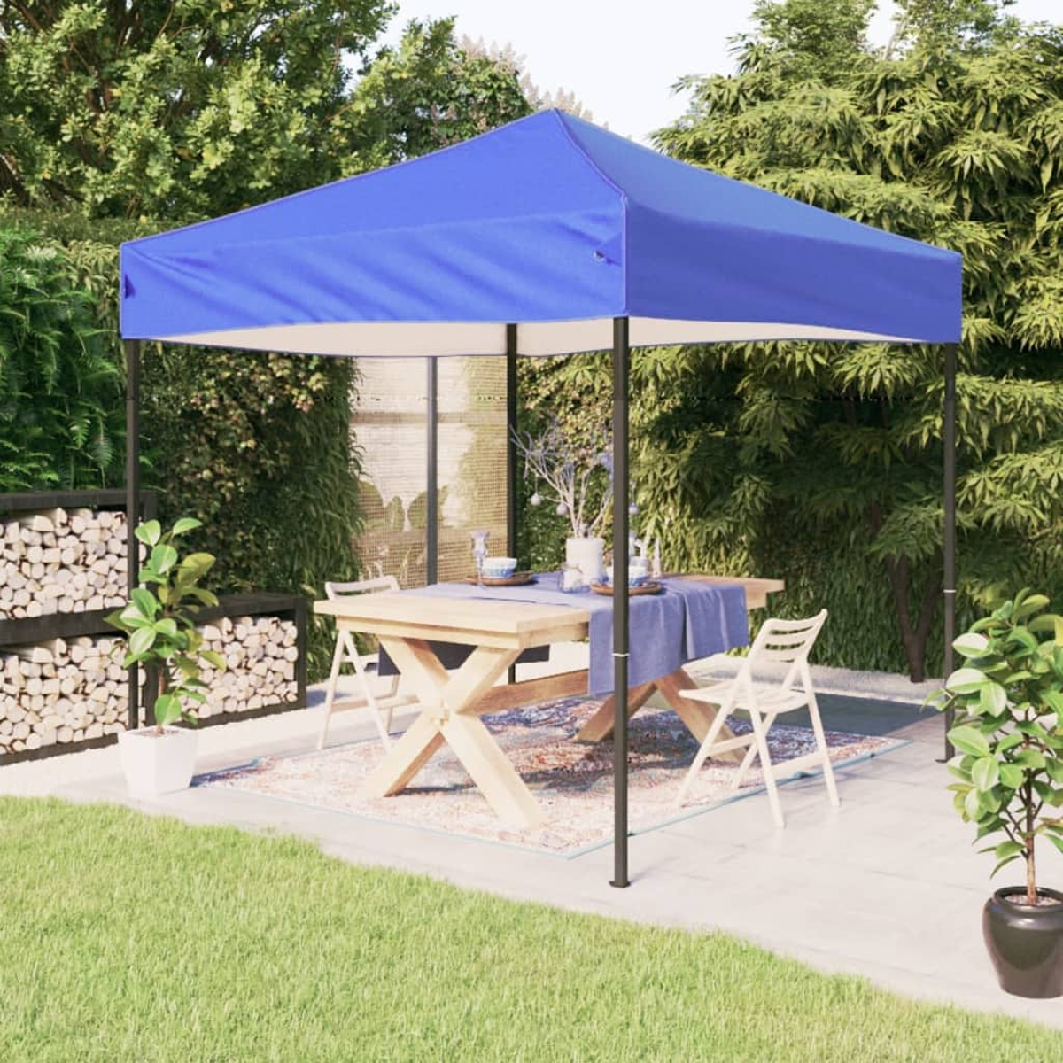 Blaues Vordach über Holztisch mit Stühlen, im Garten. Grünes Laub und Gras umgeben.