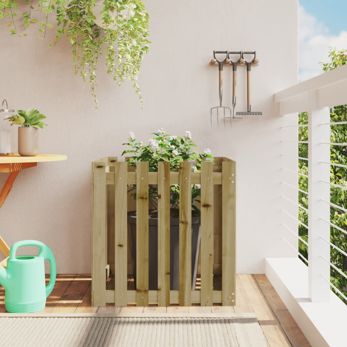 Pflanze in Holzschutz auf Balkon. Weitere Pflanzen, Gießkanne und Werkzeuge im Hintergrund.
