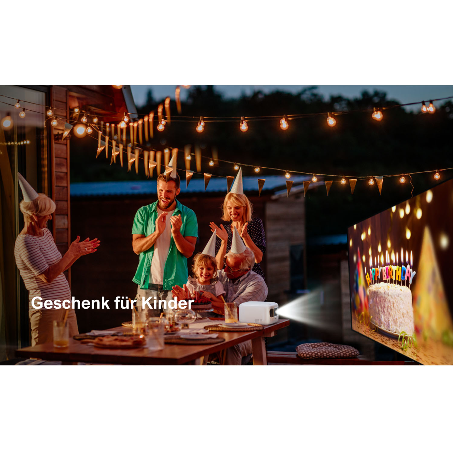 Familie feiert draußen Geburtstag, projiziert auf eine Leinwand. Text: Geschenk für Kinder.