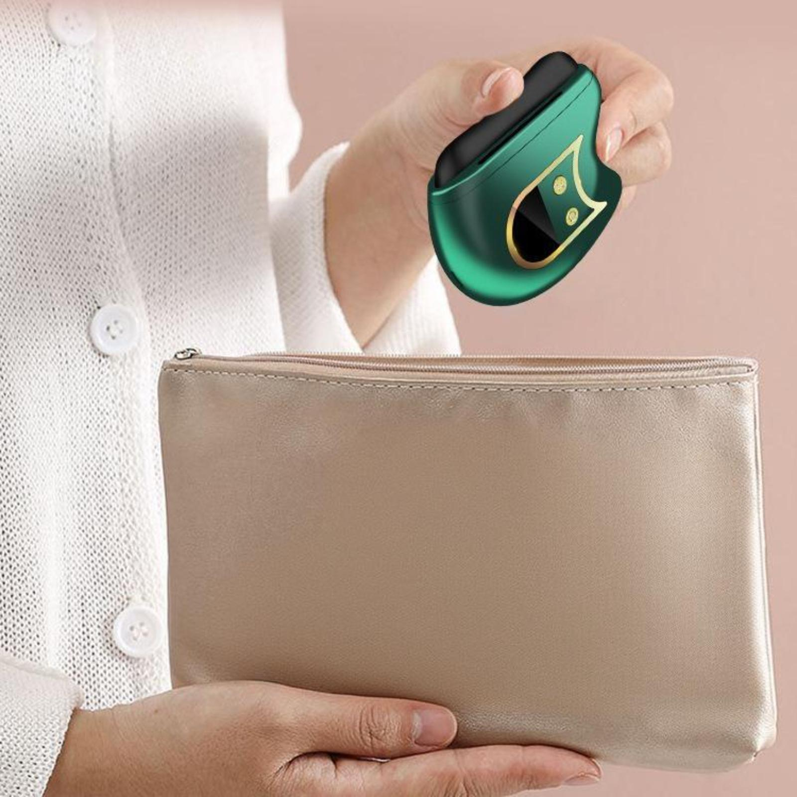 Eine Person, die ein grünes Gesichtsmassagegerät über einer beigen Kosmetiktasche hält.