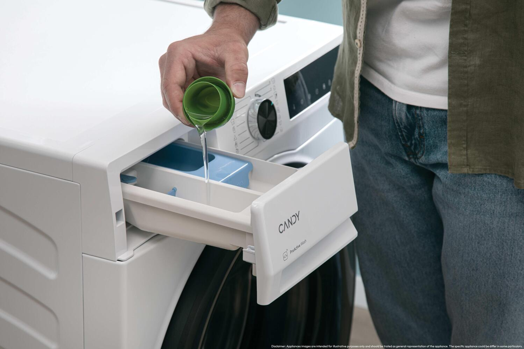 Osoba wlewa płynny detergent do otwartej szuflady na detergent białej pralki Candy.