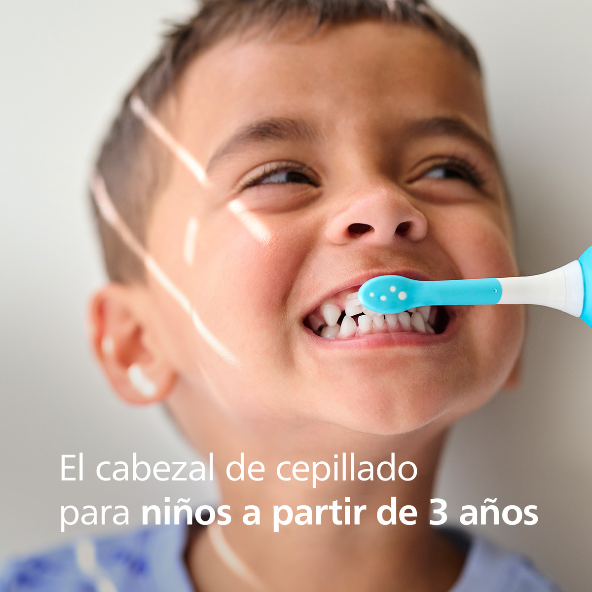 Mały chłopiec ze szczoteczką do zębów w ustach. Niebieska główka szczoteczki. Tekst: Główka szczoteczki dla dzieci od 3 lat.