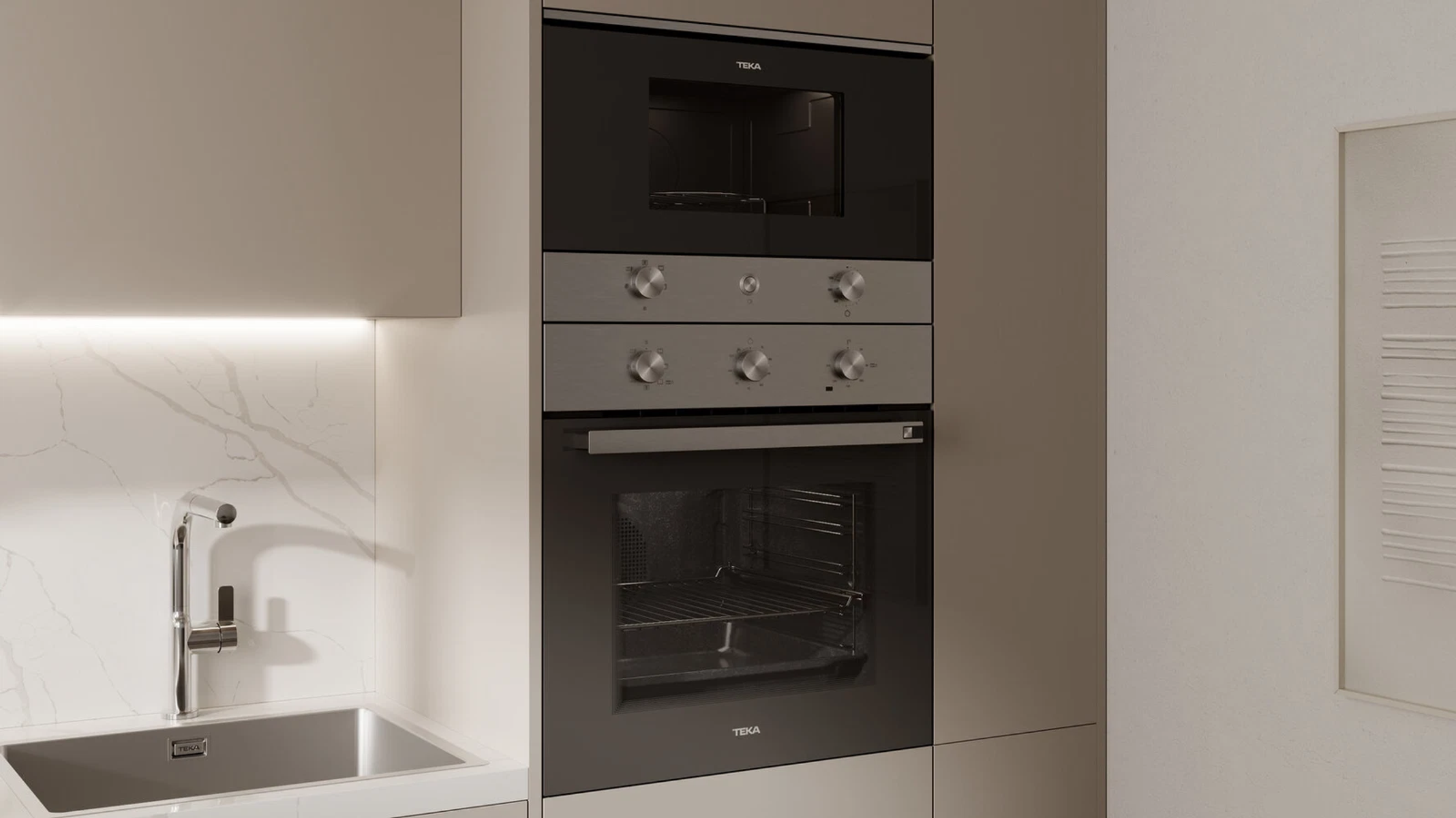 Un horno y microondas de cocina empotrados. Los electrodomésticos son de color gris oscuro, con controles de acero inoxidable. Marca TEKA.