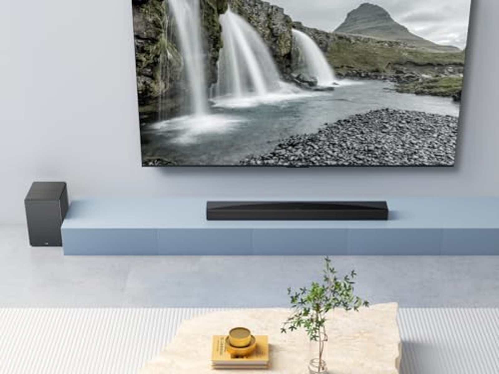 Konfiguracja salonu z telewizorem, soundbarem i subwooferem. Scena wodospadu na ekranie.