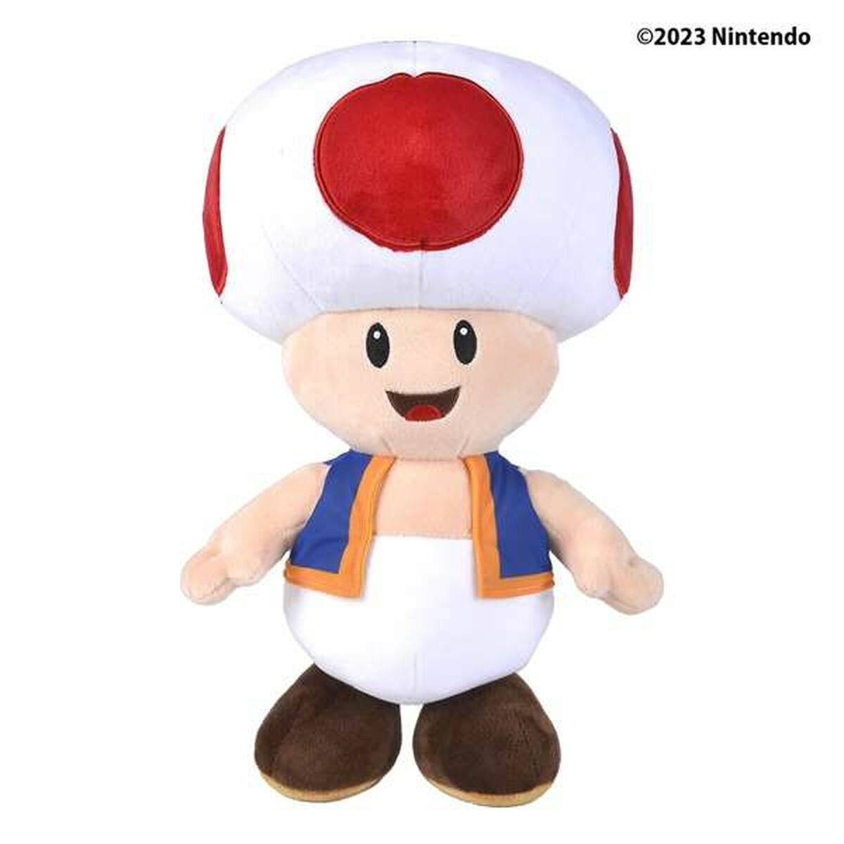 Plüsch-Toad-Spielzeug mit weißem Pilzkopf mit roten Punkten, blauer Weste und braunen Schuhen. Es lächelt.