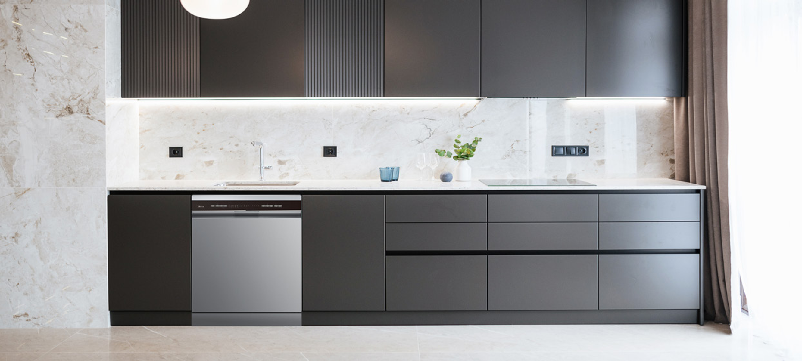 Cocina moderna con gabinetes grises y lavavajillas de acero inoxidable. Pared y encimera de mármol blanco.