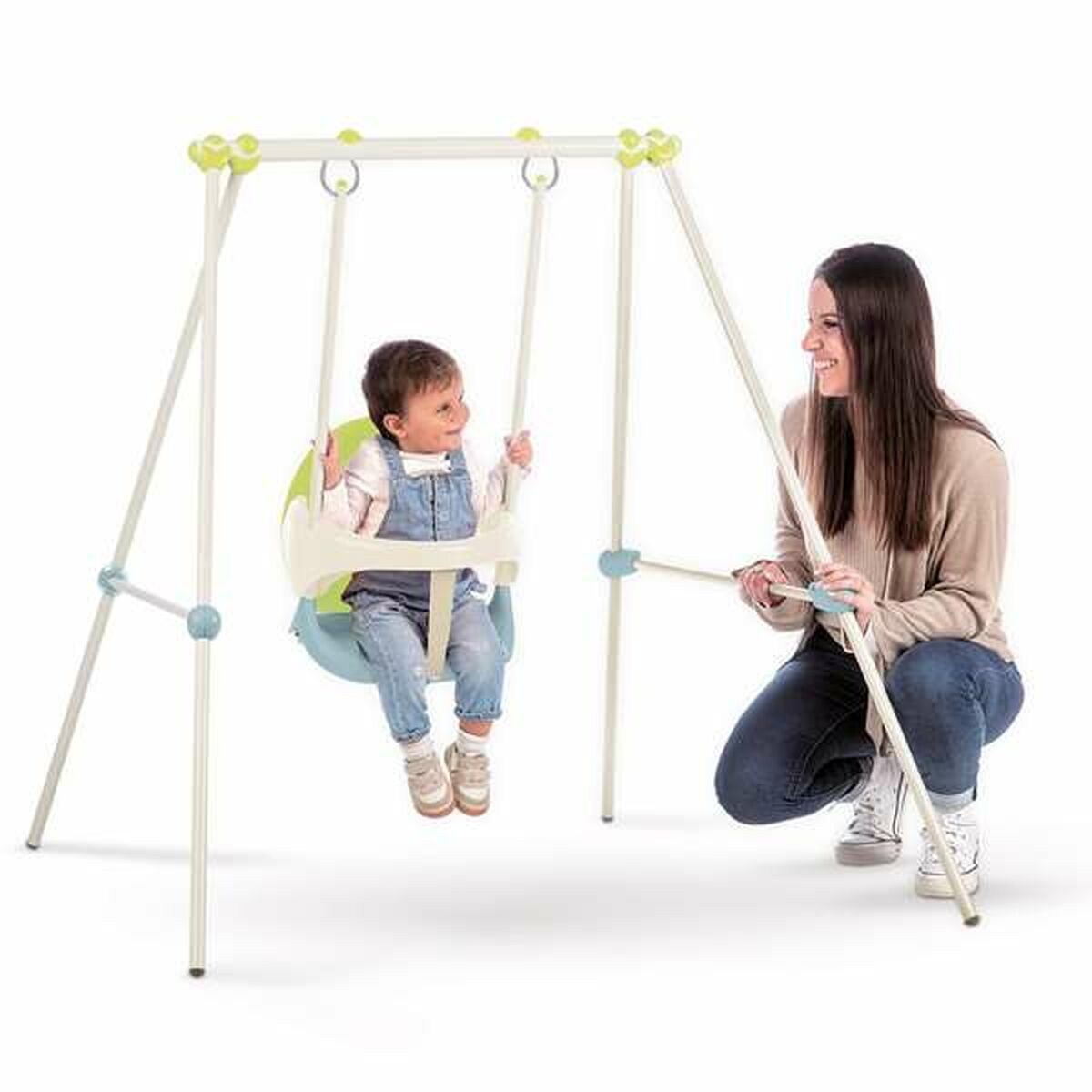 Una donna e un bambino su un'altalena. Il bambino dondola e la donna è inginocchiata, guarda e sorride.