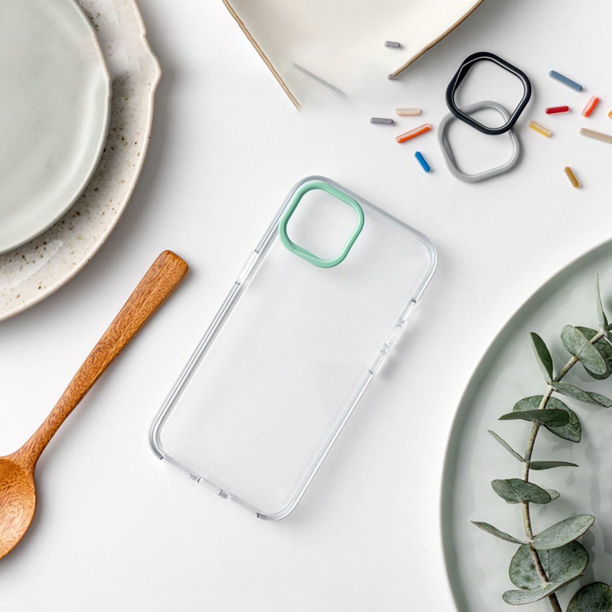 Una custodia per telefono con un anello verde attorno alla fotocamera e alcuni oggetti sul tavolo.