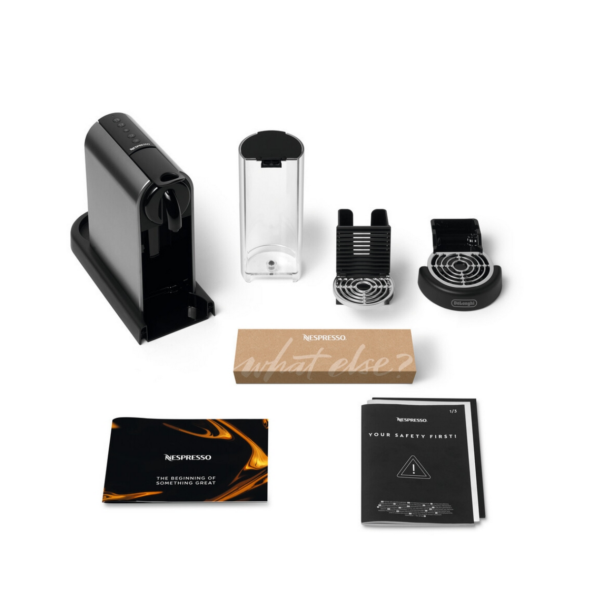 Piezas y accesorios de la máquina Nespresso colocados, con caja y manuales de instrucciones.