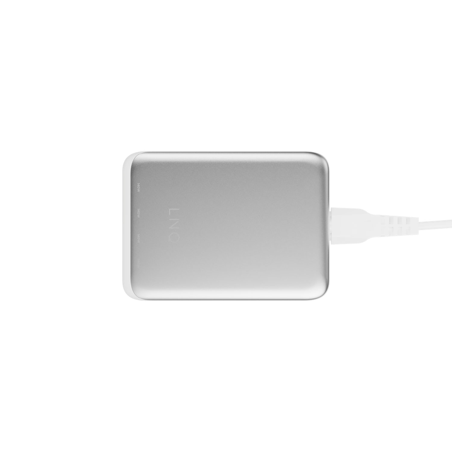 Ein silbernes Netzteil mit einem weißen Ladekabel, das eingesteckt ist, auf einer weißen Oberfläche.