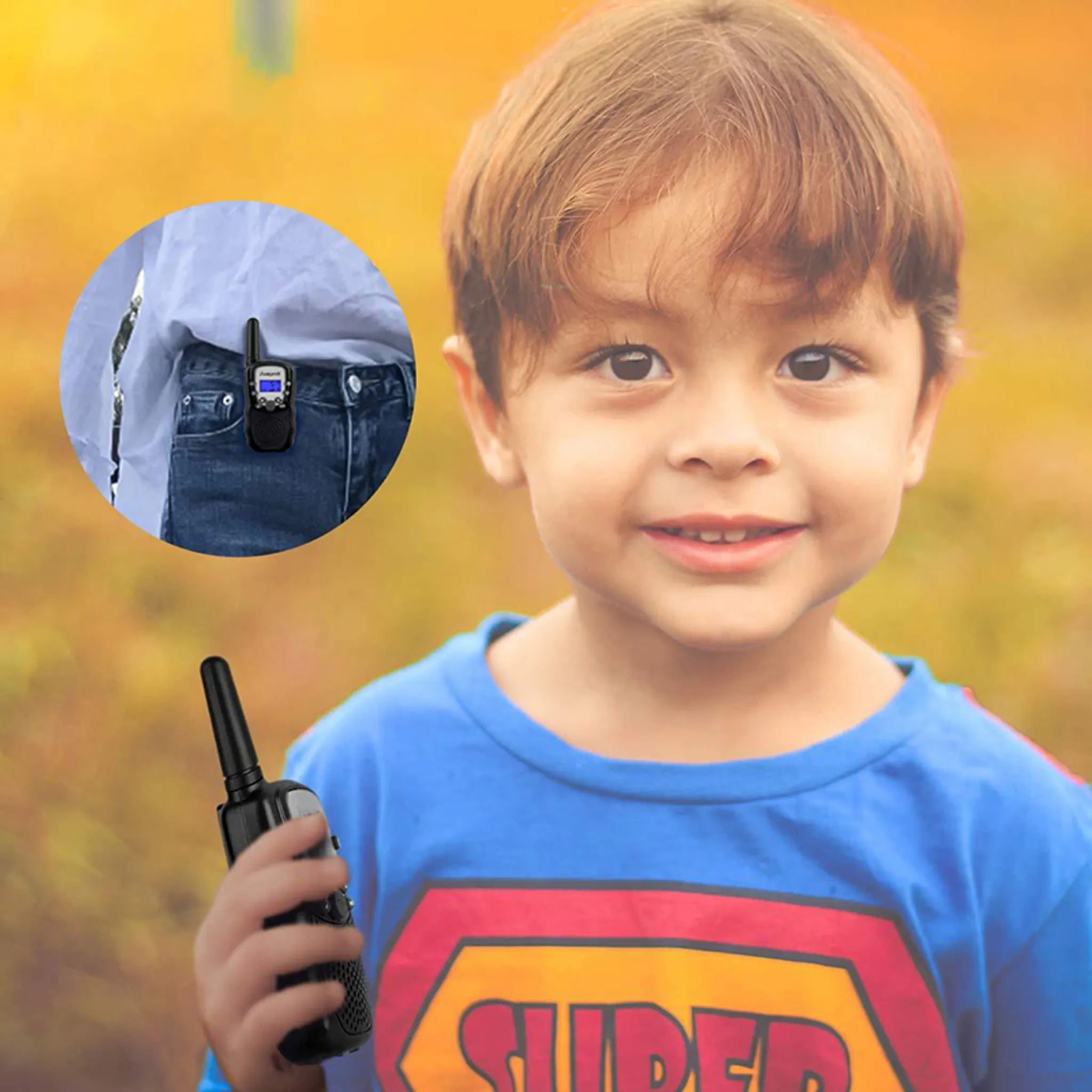 Ein Junge hält ein schwarzes Walkie-Talkie. Ein anderes ist an seiner Tasche befestigt. Er lächelt. Der Hintergrund ist unscharf.