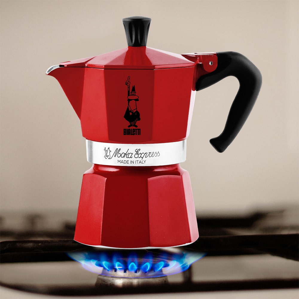 Una caffettiera Bialetti Moka Express rossa su un fornello con una fiamma blu.